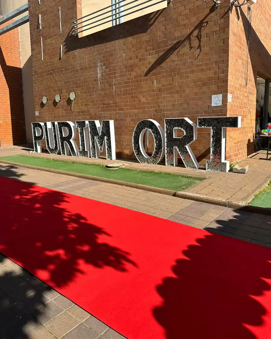אותיות פייטים ענקיות PURIM ORT ושטיח אדום בכניסה לאירוע פורים בבית ספר, בהפקת ROYAL PROM
